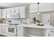 Bright kitchen features white cabinets, stainless appliances, and quartz countertops at 716 Golfview St, Orlando, FL 32804
