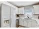White kitchen with stainless dishwasher and refrigerator, and window with natural light at 716 Golfview St, Orlando, FL 32804