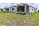 Backyard featuring a screened-in lanai, landscaping, and a well-maintained grassy area at 8925 Sw 76Th St, Ocala, FL 34481