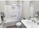 Neat bathroom with a shower-tub combination, white marble shower curtain and modern fixtures at 8925 Sw 76Th St, Ocala, FL 34481