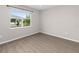 Bright bedroom with wood-look flooring, neutral walls and a large window offering a pleasant outdoor view at 8925 Sw 76Th St, Ocala, FL 34481