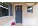 Inviting home entrance featuring a blue front door, charming window, and decorative shutter at 8925 Sw 76Th St, Ocala, FL 34481