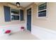Welcoming entryway with a stylish blue front door flanked by windows and decorative shutters at 8925 Sw 76Th St, Ocala, FL 34481
