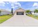 Two car garage shows a well maintained driveway and manicured lawn at 8925 Sw 76Th St, Ocala, FL 34481