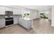 Open kitchen with stainless steel appliances, granite countertops, gray cabinets, and view into the living area at 8925 Sw 76Th St, Ocala, FL 34481