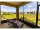 Relaxing screened-in patio with comfortable seating and a beautiful view of the green backyard and blue sky at 8925 Sw 76Th St, Ocala, FL 34481