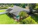 Aerial view of a well-maintained home featuring a screened-in pool and solar panels, set on a lush lawn at 5005 Se 47Th Terrace Rd, Ocala, FL 34480