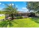Expansive backyard featuring lush green grass, mature trees and screened in pool area at 5005 Se 47Th Terrace Rd, Ocala, FL 34480