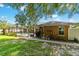 Home's backyard featuring lush lawn, mature tree, and a screened-in pool at 5005 Se 47Th Terrace Rd, Ocala, FL 34480