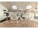 Open-concept living room with large kitchen island, hardwood floors, and bright windows at 5005 Se 47Th Terrace Rd, Ocala, FL 34480