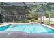 Relax in the screened-in pool area, complete with waterfall feature and view of the landscaped backyard at 5005 Se 47Th Terrace Rd, Ocala, FL 34480
