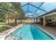 Lush backyard with a pristine screened-in pool area and an inviting patio entertainment space at 5005 Se 47Th Terrace Rd, Ocala, FL 34480
