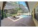 Stunning screened-in pool with lounge chairs and stylish lighting for relaxing outdoor enjoyment at 5005 Se 47Th Terrace Rd, Ocala, FL 34480
