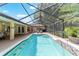 Beautiful screened pool with waterfall feature, tropical landscaping and attached patio entertainment area at 5005 Se 47Th Terrace Rd, Ocala, FL 34480