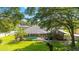 A screened-in pool offers a refreshing escape in this home surrounded by lush landscaping and mature trees at 5005 Se 47Th Terrace Rd, Ocala, FL 34480