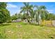 Expansive backyard featuring a fire pit, palm trees, and fresh wood fencing at 680 Nw 67Th Pl, Ocala, FL 34475