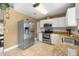 Well-lit kitchen featuring stainless steel appliances, granite countertops, and white cabinetry at 680 Nw 67Th Pl, Ocala, FL 34475