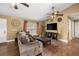Inviting living room with hardwood floors, large sofa, and decorative wall accents at 680 Nw 67Th Pl, Ocala, FL 34475