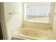 Bright bathroom featuring a soaking tub under a window, offering a relaxing retreat with natural light and a peaceful view at 2233 Ardon Ave, Orlando, FL 32833