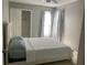 Bright bedroom featuring a white bed, closet, and sunlit window with curtains at 2233 Ardon Ave, Orlando, FL 32833