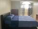 Bedroom featuring a bed with blue bedding, a chest of drawers, and a sunlit window at 2233 Ardon Ave, Orlando, FL 32833