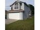 The exterior elevation of this lovely home has a two car garage and mature shade trees at 2233 Ardon Ave, Orlando, FL 32833
