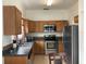 This kitchen features wooden cabinets, stainless steel appliances, and a tile floor at 2233 Ardon Ave, Orlando, FL 32833