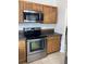 A view of a kitchen stove, microwave, and cabinets at 2233 Ardon Ave, Orlando, FL 32833