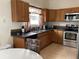 The kitchen includes wood cabinetry, stainless appliances and tile flooring at 2233 Ardon Ave, Orlando, FL 32833