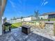 Spacious backyard with patio area, fire pit, grill, and privacy fence at 6612 Tempo Way, Groveland, FL 34736