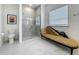 Bright bathroom with marble floors and shower, toilet and chaise lounge at 6612 Tempo Way, Groveland, FL 34736
