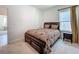 Comfortable bedroom with a dark wood bed frame, bedside table and carpet at 6612 Tempo Way, Groveland, FL 34736