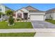 Charming one-story home featuring manicured lawn, beautiful landscaping, and a brick paved driveway at 6612 Tempo Way, Groveland, FL 34736