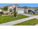 Charming one-story home featuring manicured lawn, beautiful landscaping, and a brick paved driveway at 6612 Tempo Way, Groveland, FL 34736