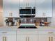Modern kitchen features white cabinets with gold hardware, quartz countertops, and stainless steel appliances at 6612 Tempo Way, Groveland, FL 34736