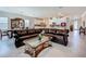Bright living room with a large leather sectional sofa, glass coffee table, and adjacent kitchen and dining area at 6612 Tempo Way, Groveland, FL 34736