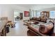 Open-concept living room featuring a leather sectional sofa, glass coffee table, and formal dining area at 6612 Tempo Way, Groveland, FL 34736