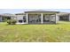 Backyard view of the screened-in lanai complemented by lush green grass and landscape at 9478 Sw 52Nd Loop, Ocala, FL 34481