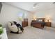 Comfortable bedroom featuring a ceiling fan, a massage chair, and a large window at 9478 Sw 52Nd Loop, Ocala, FL 34481