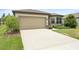 Home exterior showing a two-car garage, landscaped yard, and concrete driveway at 9478 Sw 52Nd Loop, Ocala, FL 34481