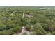 Expansive aerial view of a heavily wooded homesite featuring a long driveway and a small house at 221 Se 167Th Ct, Silver Springs, FL 34488