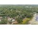 Aerial view showing a wooded homesite with a long driveway, near a body of water at 221 Se 167Th Ct, Silver Springs, FL 34488
