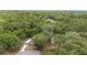 Aerial shot showcasing the home, carport, and outbuilding nestled within a dense woodland landscape at 221 Se 167Th Ct, Silver Springs, FL 34488