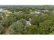 Aerial view of a house surrounded by dense trees; black car in the driveway at 221 Se 167Th Ct, Silver Springs, FL 34488