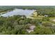 Aerial shot reveals a house amidst a lush, green forest and large body of water at 221 Se 167Th Ct, Silver Springs, FL 34488