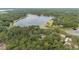 Wide aerial view showing house nestled within a dense forest next to a lake at 221 Se 167Th Ct, Silver Springs, FL 34488