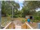 Wooden steps looking into a wild backyard with a shed and lush, tropical foliage at 221 Se 167Th Ct, Silver Springs, FL 34488
