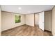 A bedroom has wood-look flooring and a window view with an attached bathroom at 221 Se 167Th Ct, Silver Springs, FL 34488