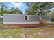 Exterior of home featuring gray siding, white trim, wood steps and partial landscaping at 221 Se 167Th Ct, Silver Springs, FL 34488