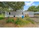 Exterior view of the home featuring an AC unit, landscaping, and mature shade trees at 221 Se 167Th Ct, Silver Springs, FL 34488